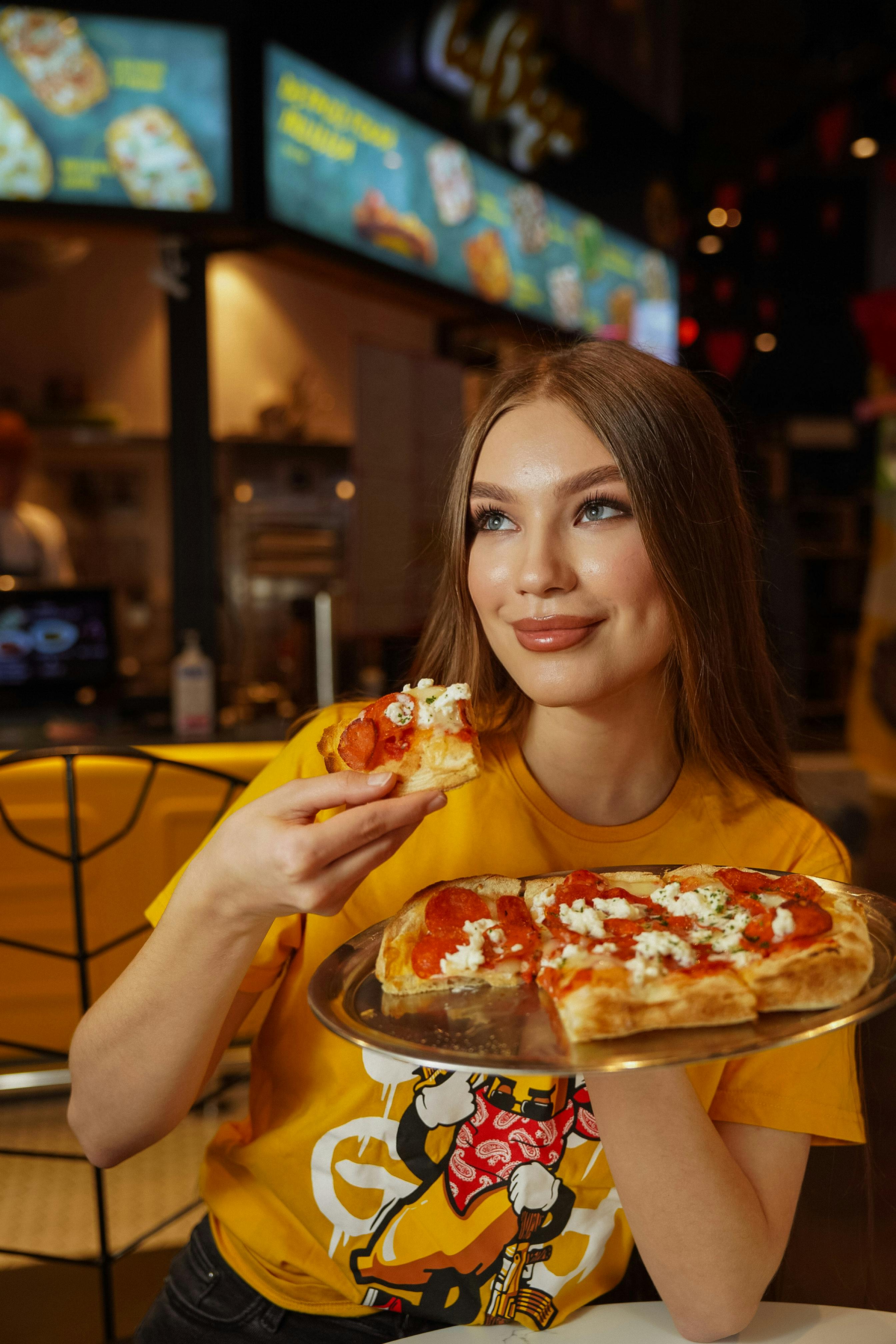 Woman Eating Pizza in Restaurant